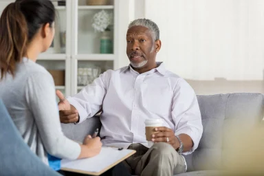 Senior man discussing options with a counselor taking notes on a clipboard