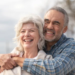 Close-up of a smiling couple embracing outdoors