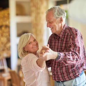 Low Reverse Mortgage Quotes Explained Senior couple dancing together and smiling in a living room