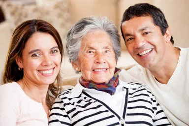 Three generations of a family posing closely together and smiling