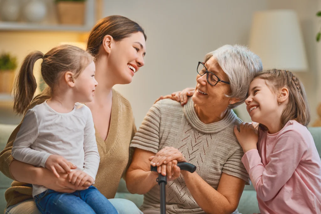 Grandmother using a cane surrounded by her daughter and granddaughters
